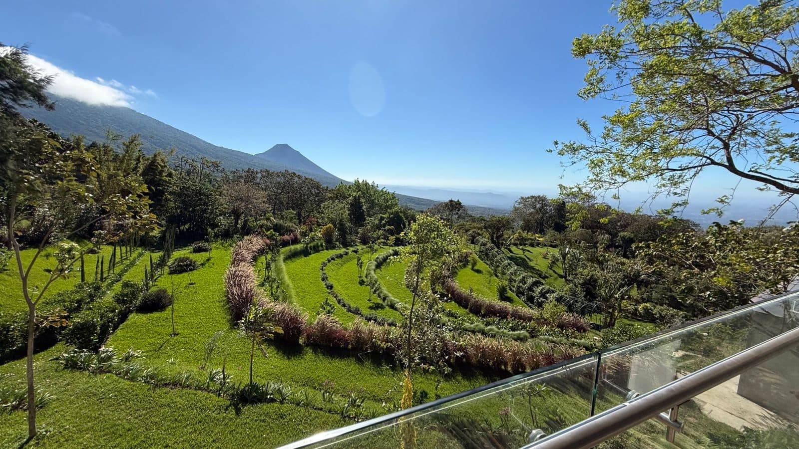 View from Casa Conejo main building over terraced gardens with volcano and Pacific coast in background